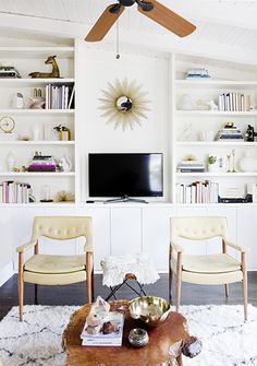 a living room with two chairs and a tv on the wall above it is an article about how to use ikea kitchen cabinets in living room shelving