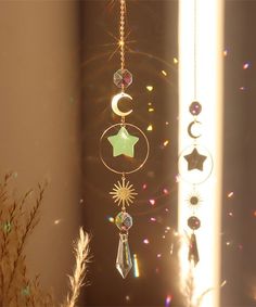 a wind chime hanging from the side of a window with stars and crescents