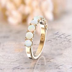 a gold ring with white opal stones on it