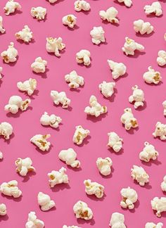 white popcorn on a pink background with small pieces cut out to look like bears and elephants