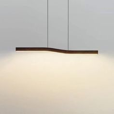 a modern light fixture hanging from the ceiling in a room with white walls and flooring