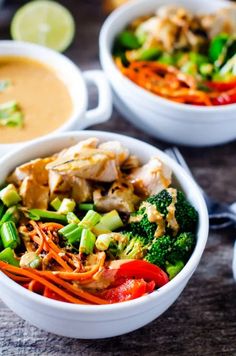 two white bowls filled with different types of vegetables and sauces next to each other