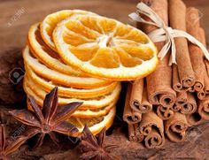 cinnamons, orange slices and star anise are arranged on a wooden table with cinnamon sticks