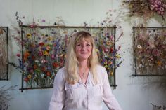 a woman standing in front of some flowers