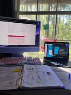 two computer monitors sitting on top of a desk next to a keyboard and monitor screen