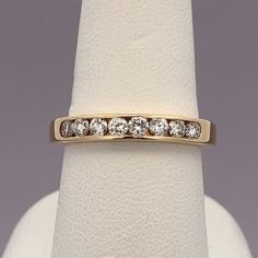 a gold ring with five diamonds on it