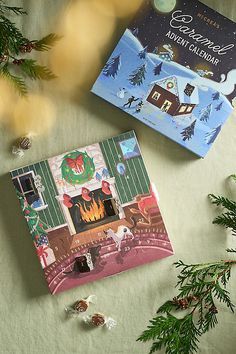 two christmas cards sitting on top of a table