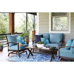 an outdoor living room with blue furniture and pillows on the couches is featured in this article