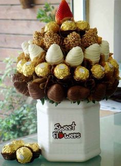 a white vase filled with lots of chocolates and strawberries