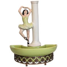 a figurine is standing on top of a fountain with a ballerina in it