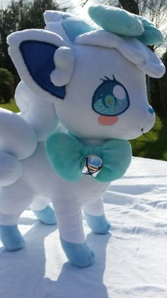 a stuffed animal with a bell around its neck on top of a snow covered ground