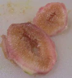 two pieces of fruit sitting on top of a cutting board