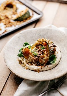 a white plate topped with food on top of a wooden table next to a fork