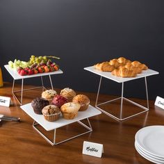 three trays with pastries on them sitting on a table next to plates and forks