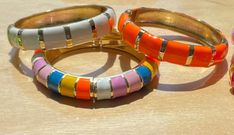 Colorful bangles! In 7 scintillating colors :) Here are the white, orange, and rainbow bracelets, each sold separately. Please check the dimensions of each bracelet: the blue, orange, pink, purple, and white are 2.3" in diameter and 0.5" high.  The multicolored bamboo style (pink, blue and yellow) and green bamboo are slightly larger, at 2.5" diameter and 0.6" high.  All close with a snap hinge. Like everything in our shop, this bracelet SHIPS FREE.  Wink and Flip, a STAR SELLER, celebrates 14 y Bold White Jewelry For Gift, Bold White Jewelry For Gifts, Orange Bangle Bracelets For Party, Trendy White Bangle As A Gift, Trendy White Bangle For Gift, Trendy White Bangle As Gift, Trendy Orange Bangle Bracelets, Taylor Tomasi, Taylor Tomasi Hill