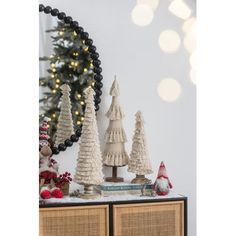 christmas decorations on top of a dresser in front of a mirror