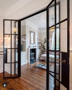 an open door leading to a living room with wood floors and furniture in the background