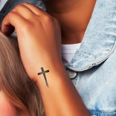 a woman with a cross tattoo on her arm