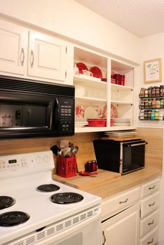 a kitchen with white cabinets and black microwave