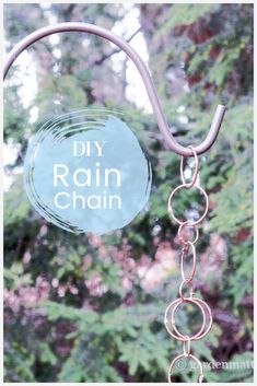 a close up of a metal chain hanging from a tree with the words diy rain chain on it