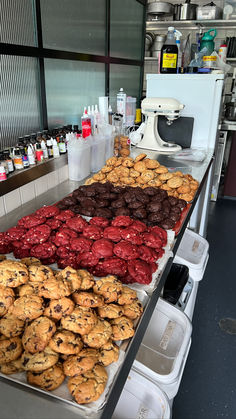 several trays of cookies and other pastries on a counter in a kitchen area