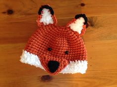 a knitted fox hat sitting on top of a wooden floor