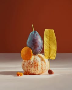 an orange, figurine and leaf sitting on top of each other in front of a brown background