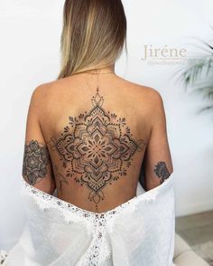 the back of a woman's body with tattoos on it