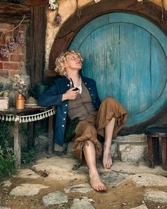 a woman sitting in front of a blue door