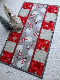 a quilted table runner with snowmen on it