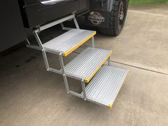 two step stools are attached to the side of a truck