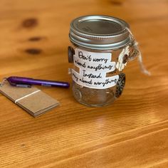 a jar with some writing on it sitting next to a pen and paper clipping