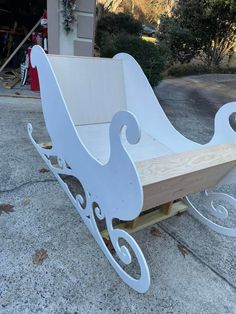 a white sleigh sitting on top of a sidewalk