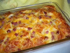 a casserole dish with ham and cheese in it sitting on a table next to a towel