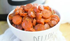 a white bowl filled with cooked carrots next to an instant pot roaster oven