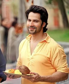 a man holding a plate with food on it