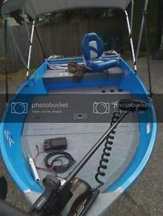 a small boat is sitting on the ground next to some wires and other things that are attached to it