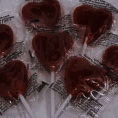 six heart shaped lollipops wrapped in plastic wrappers