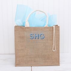 a burlap bag with the word shg on it and some blue tissue bags