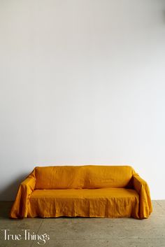 a yellow couch sitting in front of a white wall