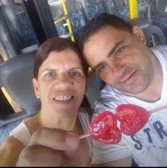 a man and woman are holding lollipops in front of their faces on a bus