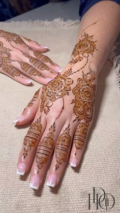 two hands with henna tattoos on them