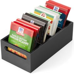 a black box with compartments filled with different types of food and drink packets in it