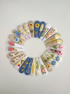 a circle of wooden spoons with flower designs on them, all in different colors