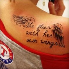 the back of a woman's shoulder with an angel wing tattoo on her upper arm