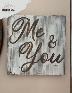 a wooden sign that says me and you on it next to a wall with a clock