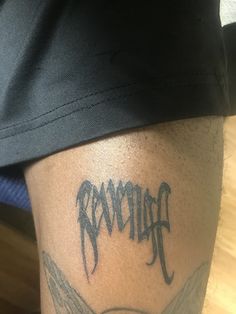 a man with a tattoo on his leg that says hammer and is holding a skateboard