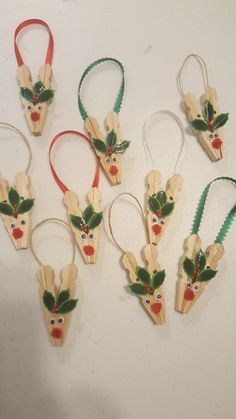 six wooden ornaments with holly leaves and red berries on them, hanging from the wall