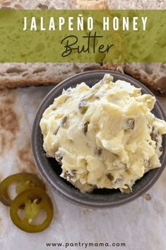 a bowl filled with butter next to some sliced bread and an onion on the side