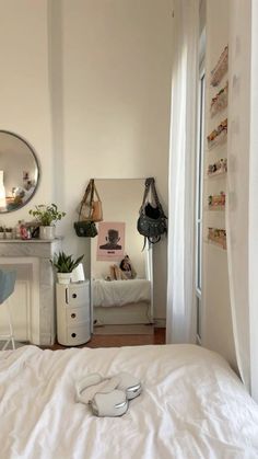 a bedroom with a white bed, mirror and desk in the corner next to it